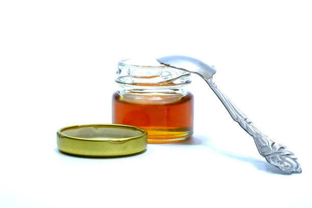 istock Honey in a glass bottle White background 1039661852