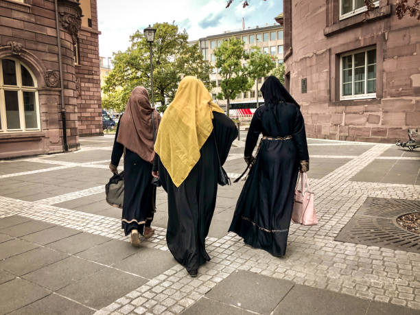 Middle East, Saudi Arabia, Riyadh, Al-Dirah. November 11, 2023. Woman with two umbrellas at the Souq Al-Zal.