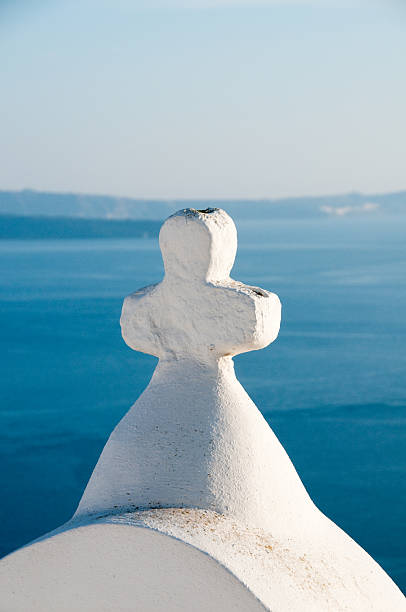 A blue domed church in Oîa Santorini with flowers in the foreground