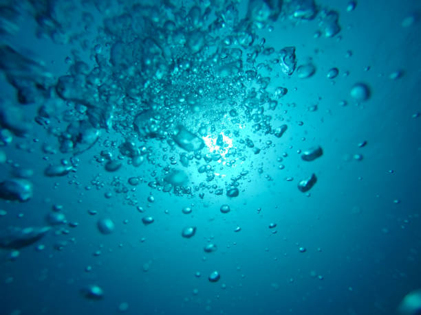 istock Air Bubbles Going to the Surface and Towards the Sun in a Blue Sea 1039683064