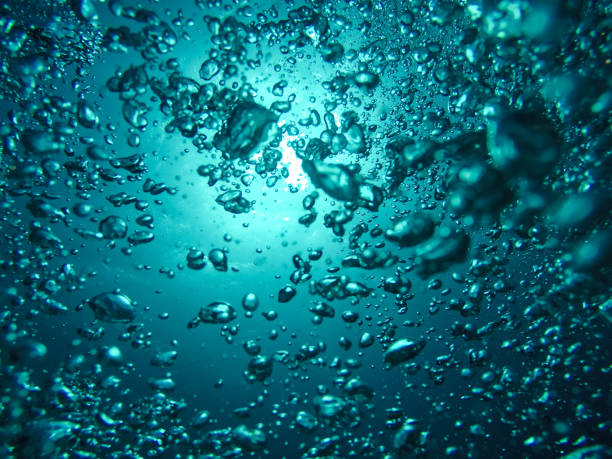 istock Air Bubbles Going to the Surface and Towards the Sun in a Blue Sea 1039687478