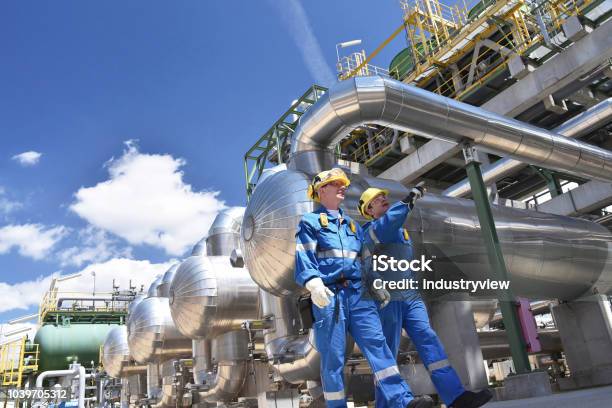 Group Of Industrial Workers In A Refinery Oil Processing Equipment And Machinery Stock Photo - Download Image Now
