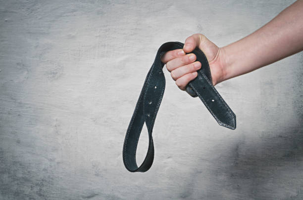 Domestic violence Hand holds leather belt for punishment. Family violence concept. belt stock pictures, royalty-free photos & images