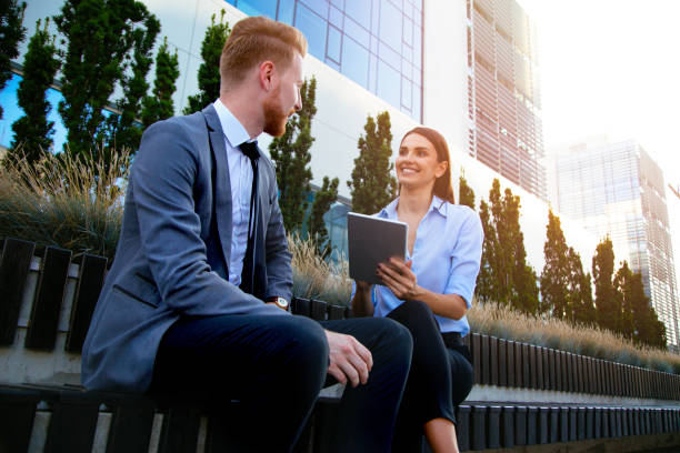 istock Two business people talking after work in the city park 1039710484