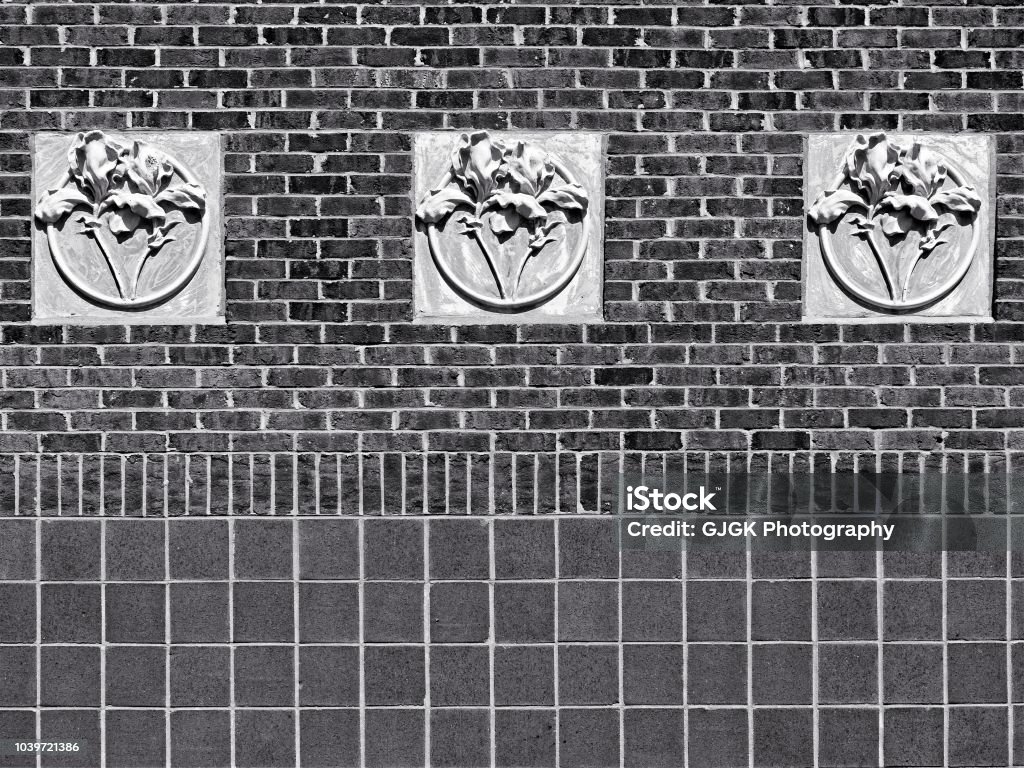 Concrete 3 Flowers on Red Brick Wall B&W New Orleans, LA USA - May 9, 2018  -  Concrete 3 Flowers on Red Brick Wall at Tulane University B&W Abstract Stock Photo