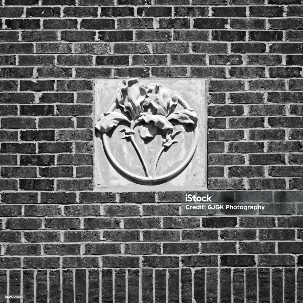 Concrete Flower on Red Brick Wall B&W New Orleans, LA USA - May 9, 2018  -  Concrete Flower on Red Brick Wall Tulane University B&W Abstract Stock Photo