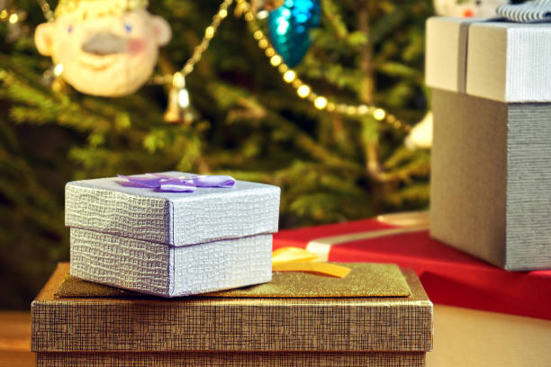 istock Gift boxes with bows on the lids under a Christmas tree in New Year Eve 1039726542