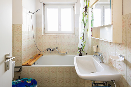 Vintage bathroom with green tiles and window. Nobody inside