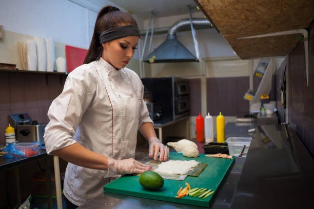 istock woman Cook prepares sushi on restaurant kitchen 1039733224