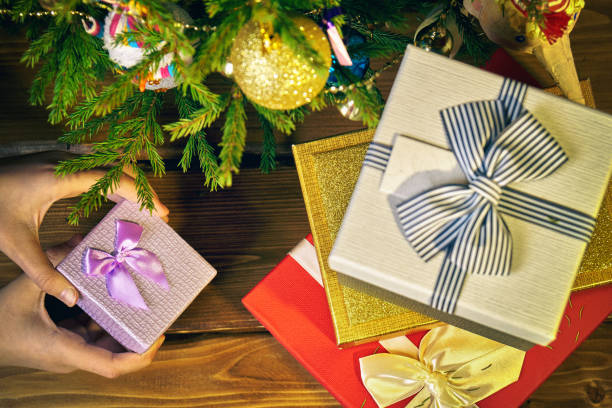 istock Girl's hands open a little gift box from under a Christmas tree 1039733380