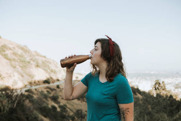 istock Woman drinking water while trekking 1039734072