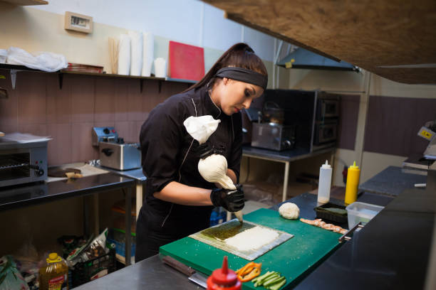 istock woman Cook prepares sushi on restaurant kitchen 1039739844