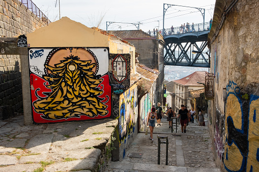 Porto, Portugal - September 16, 2018 : People ascending the Rua Stairs of the Codeçal in the city of the Porto, houses in ruins and with graffiti Porto, Portugal
