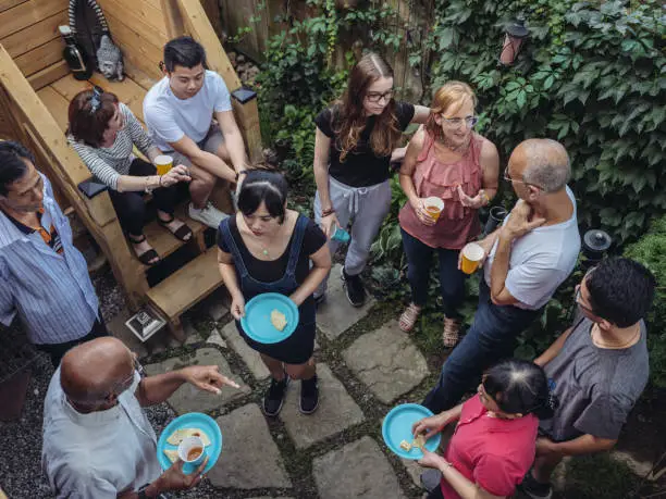 Diverse group of people having an outdoor party in the garden of urban home in North American city.