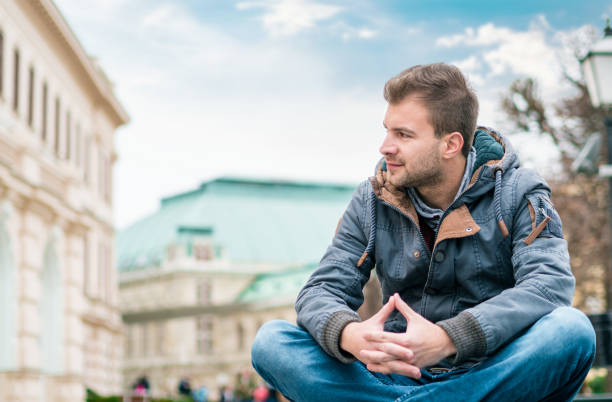 istock Young man looking to side and sitting. Guy wearing warmly or winter jacket 1039782890