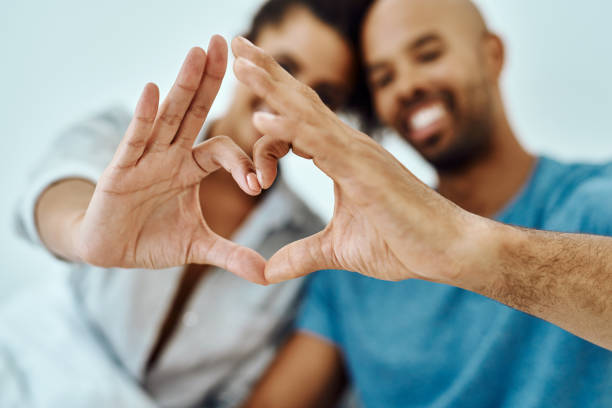 Love gives life meaning Defocused shot of a couple forming a heart with their hands heart hands multicultural women stock pictures, royalty-free photos & images