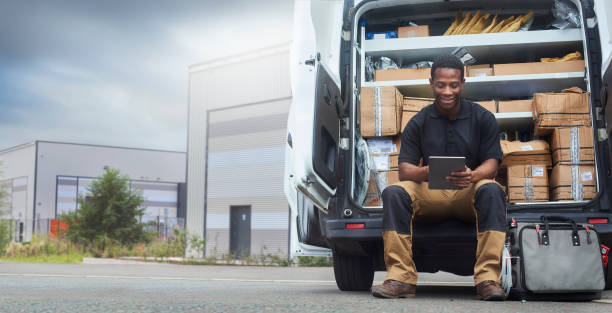 un technicien était assis à l’arrière de son van - box package delivering mail photos et images de collection