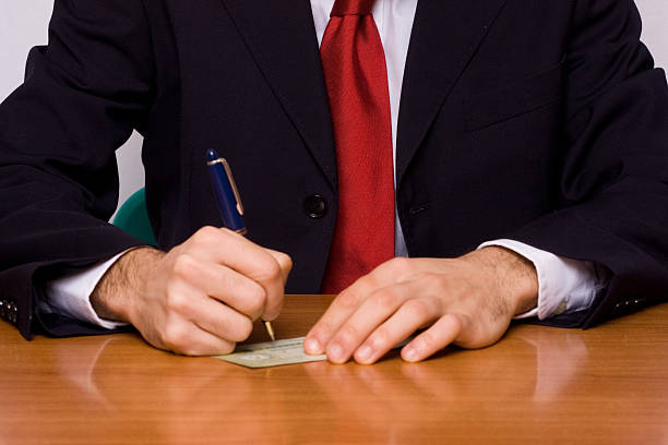 istock Young Businessman Sign a Cheque on the Table 103980299