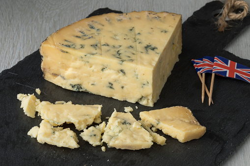 Old mature wedge of British blue Stilton cheese and pieces