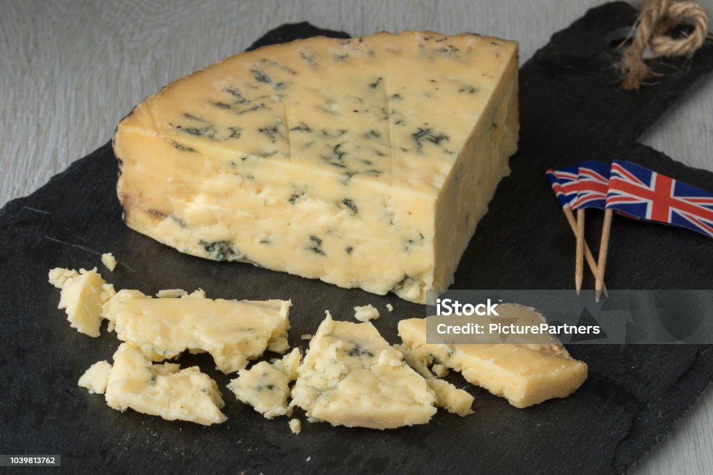 Old mature wedge of blue Stilton cheese Old mature wedge of British blue Stilton cheese and pieces Stilton Cheese Stock Photo