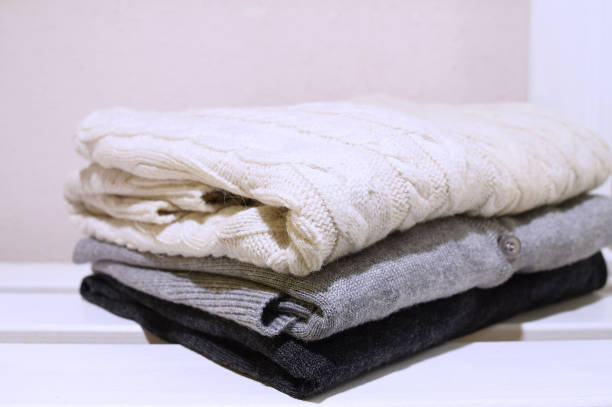 istock Knitted wool sweaters close up Selective focus Winter clothes White wooden background copy space Shopping 1039818986