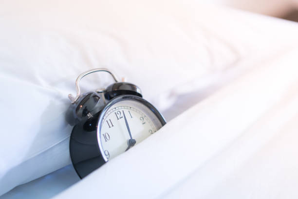 istock Metal Alarm clock on white bed 8 am. 1039822328