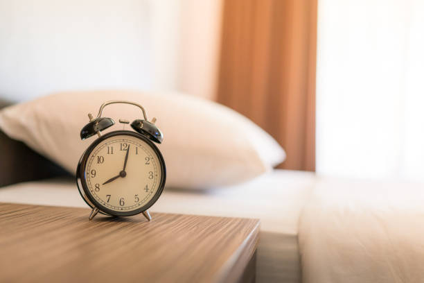 istock Metal Alarm clock on white bed 8 am. 1039822404