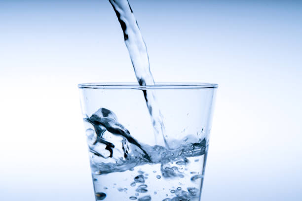 istock Close up pouring drinking water into glass, studio shot 1039822784