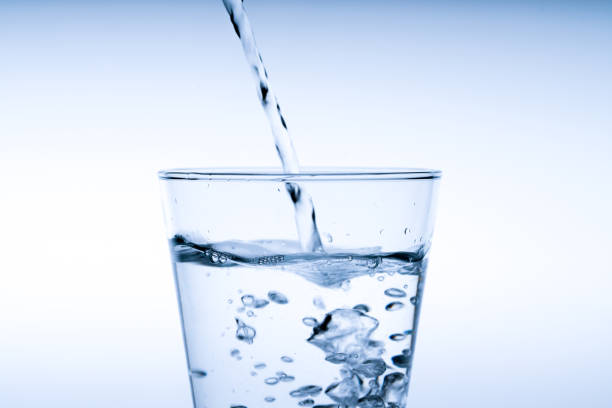 istock Close up pouring drinking water into glass, studio shot 1039825038