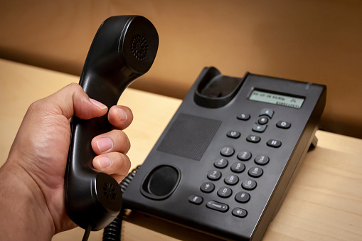 Picking up a phone call from a black telephone