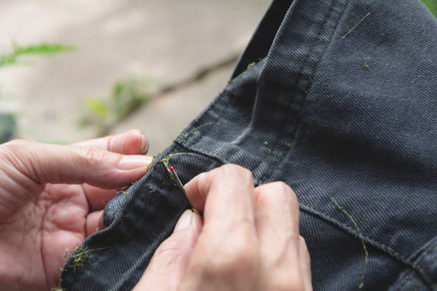 istock Hand holding and using sewing seam ripper. Ripping a seam with a ripper. 1039837758
