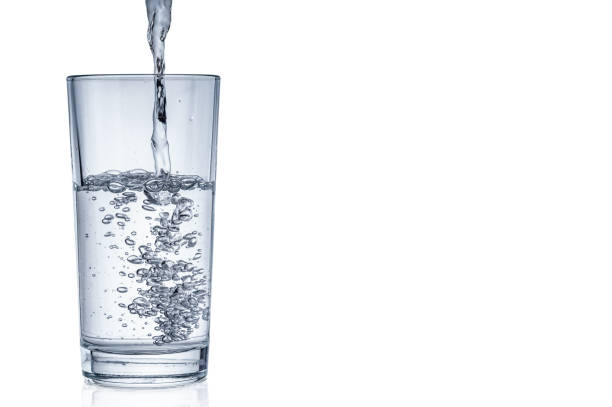 istock Flowing pure water into tumbler on white background 1039841130