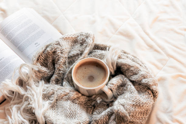 istock Hot drink on a shawl and open book 1039874300
