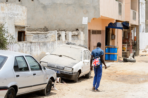 LAC ROSE reg. , SENEGAL - APR 27, 2017: Unidentified Senegalese man walks along the street from behind.