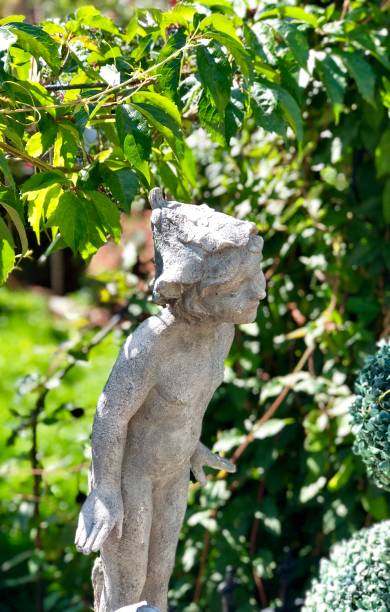istock Statue of small child outside garden gate 1039893090