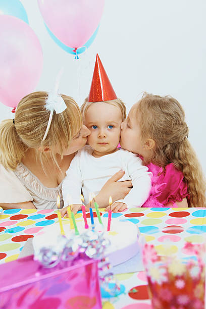 femmes célébrant l'anniversaire de son fils et sa fille - single mother one parent child kissing photos et images de collection