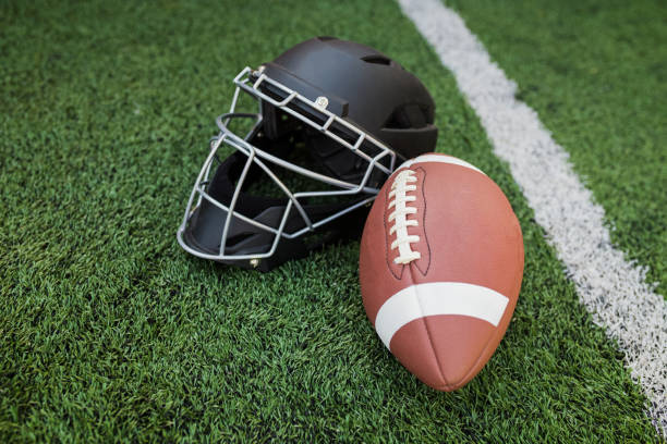 istock Rugby helmet with ball on green grass 1039903116