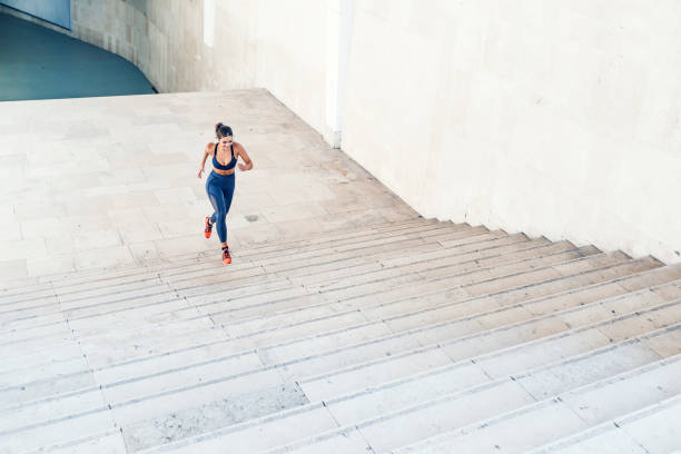 istock Sporty woman running up steps in urban setting 1039922780