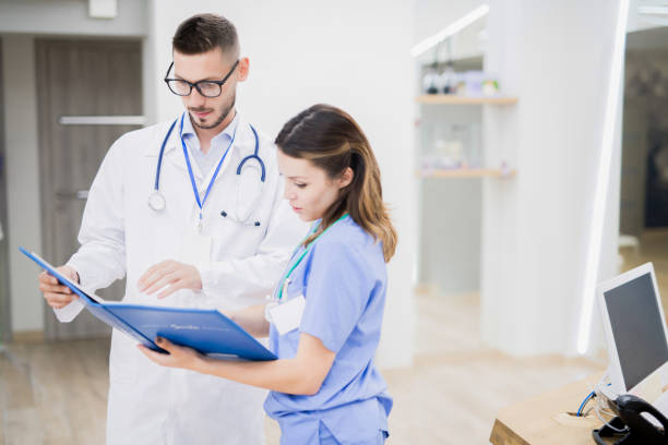 istock Serious concentrated doctors analyzing information in book while discussing work in clinic hall 1039923226