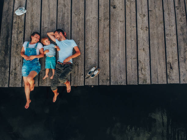 liebevolle familie auf eine reise nach lake - sea high angle view water tranquil scene stock-fotos und bilder