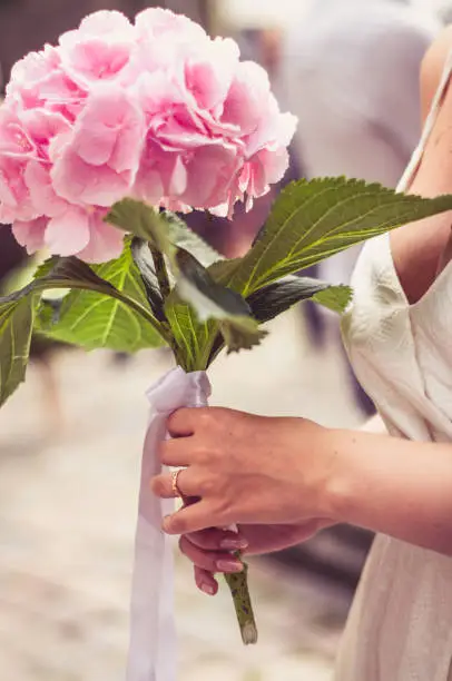 Ring on her finger and holding hydrangea