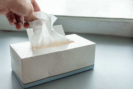 Hand picking white tissue paper from package box