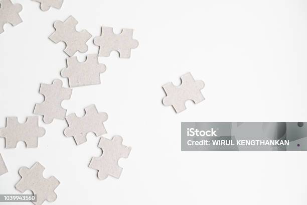 Unfinished White Jigsaw Puzzle Pieces On White Background Stock Photo - Download Image Now