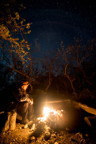 istock Man near the burning bonfire in the night under a starry sky 1039944274