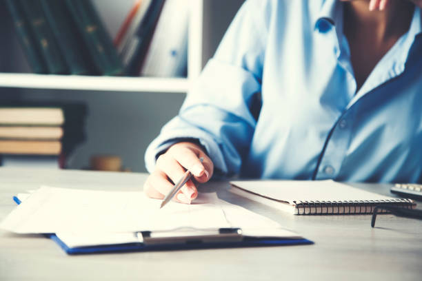 istock woman hand writing or signing in a document on a desk 1039946876