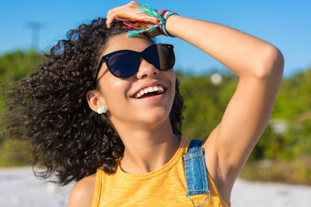 wesoła roześmiana dziewczyna na plaży - women moving up looking human hair zdjęcia i obrazy z banku zdjęć