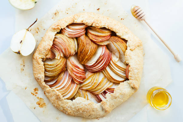 Apple and pear galette. Apple and pear tasty galette with honey on the table. Open autumn pie, top view. galette stock pictures, royalty-free photos & images