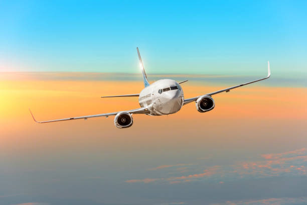 istock Passanger airplane above the clouds horizon sky with bright sunset colors. 1039963232