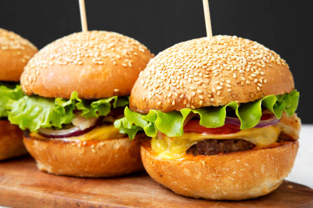 istock Cheeseburgers on wooden board, side view. Close-up. 1039971396