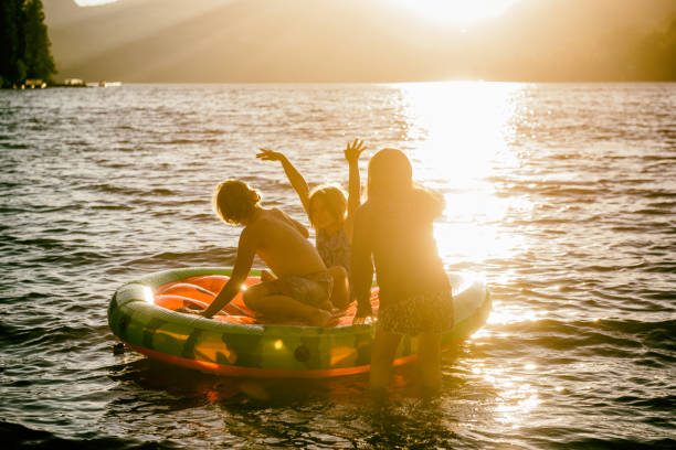 친구와 가족 일몰에서 아름 다운 호수에 팽창 식 뗏목에 재생 - child inflatable raft lake family 뉴스 사진 이미지